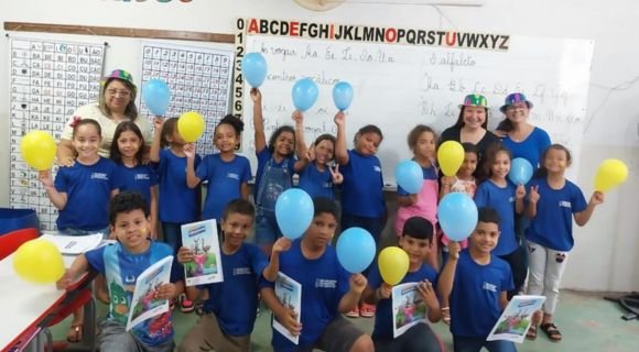 Criança na escola com livro e balão